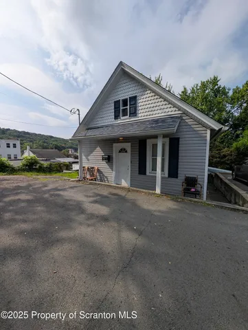 a view of a house with a patio and a yard