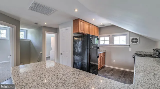 a kitchen with stainless steel appliances granite countertop a refrigerator and a sink