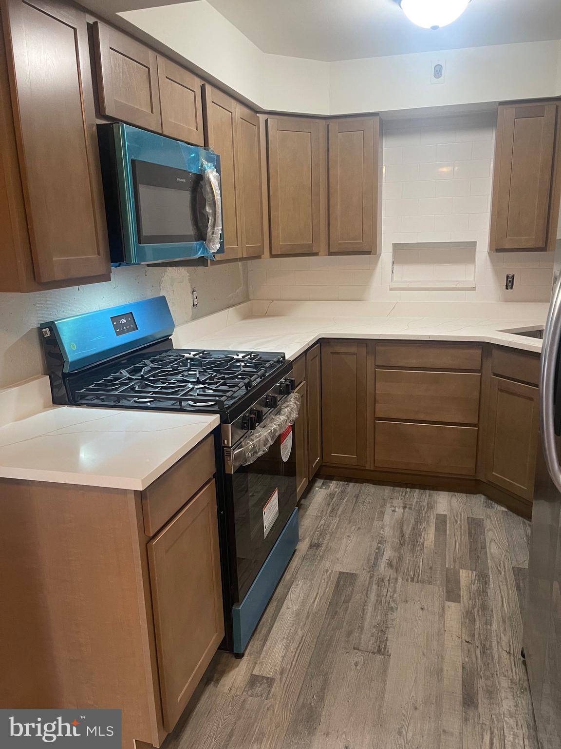 201 South Augusta Avenue, Unit A5 Baltimore, MD 21229 - Photo 6 of 12 a kitchen with stainless steel appliances granite countertop a sink stove and microwave