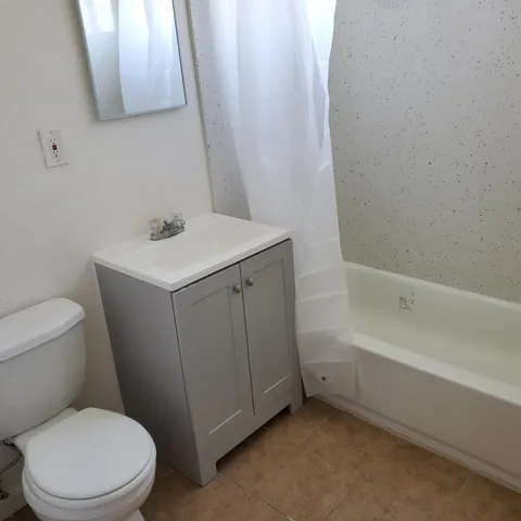a white toilet sitting next to a white sink