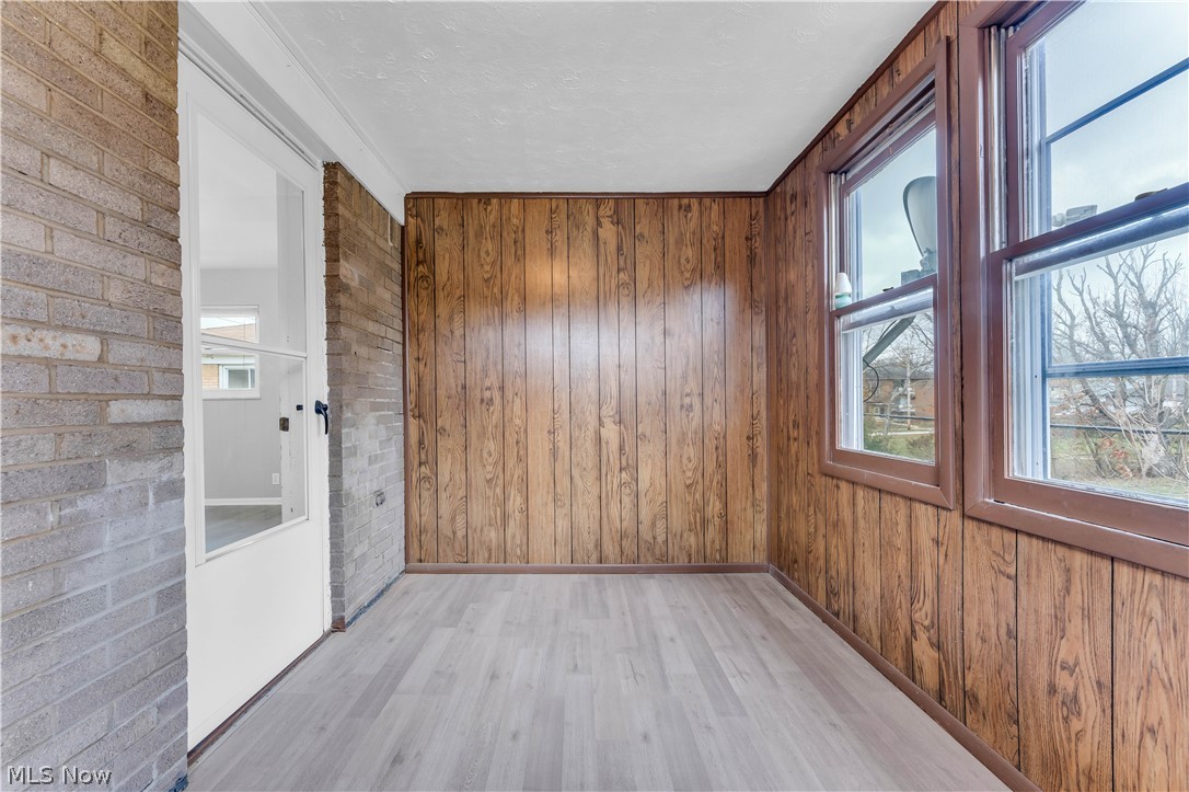 2915 Snow Road, Unit 2/UP Cleveland, OH 44134 - Photo 17 of 23 Sunroom featuring wood-look wall paneling, light wood-finish flooring, and multiple window units