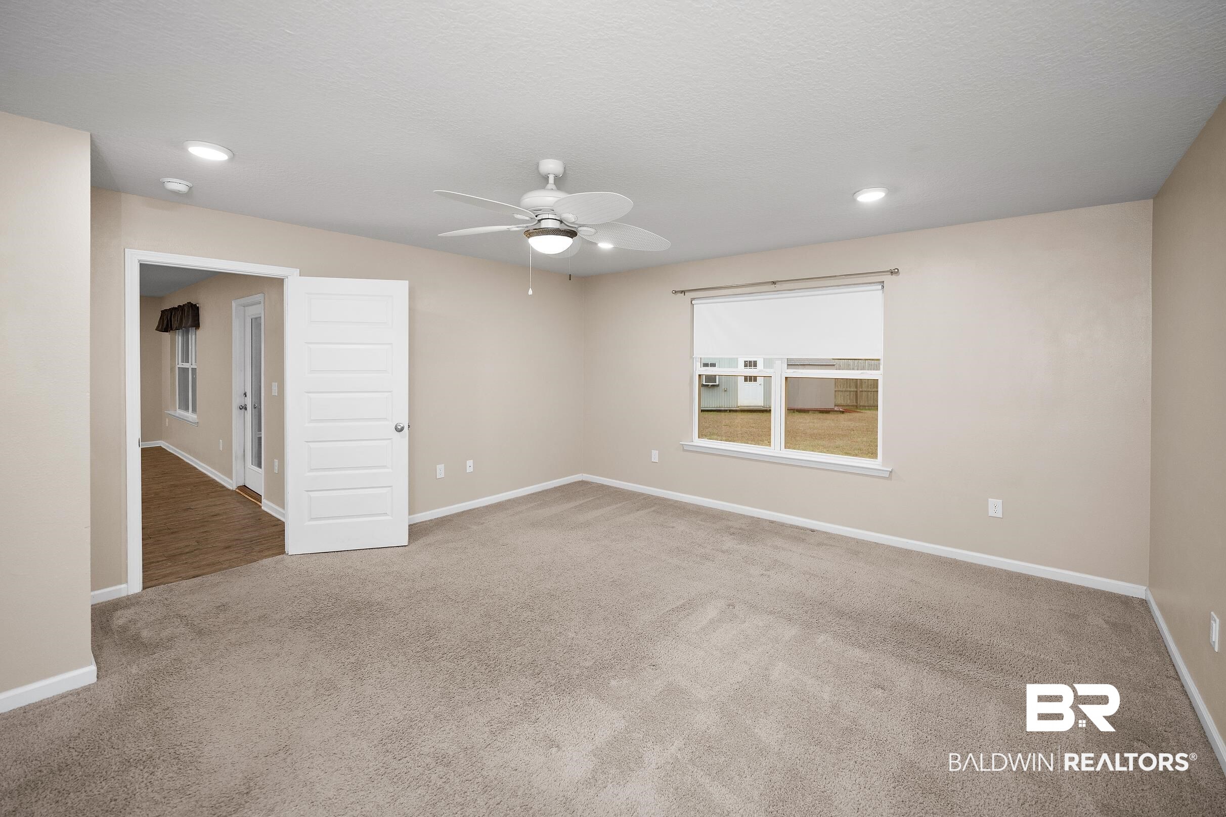 8294 Irwin Loop Daphne, AL 36526 - Photo 12 of 29 Carpeted interior space featuring a ceiling fan with integrated lighting, recessed lighting, and a single window with a roller shade