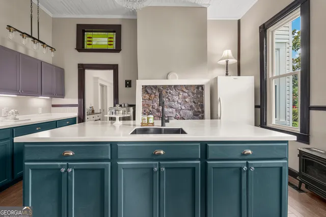 a kitchen with kitchen island granite countertop a sink a counter top space stainless steel appliances and a window