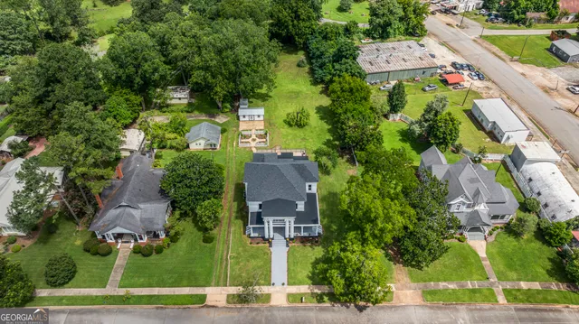 an aerial view of a house with a yard swimming pool and outdoor seating