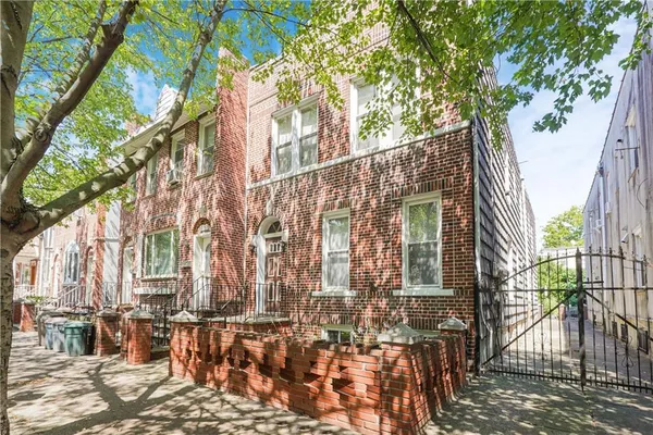 a view of a brick house with a large windows and wooden bench in a patio