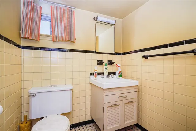 a bathroom with a sink toilet and a mirror