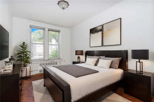 a bedroom with a large bed and a potted plant