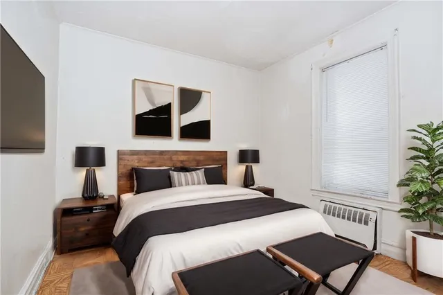 a bedroom with a bed and a potted plant