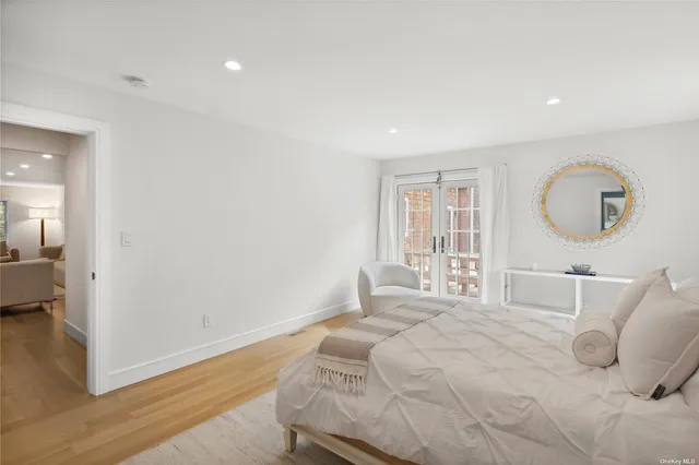 a bedroom with a large bed and wooden floor