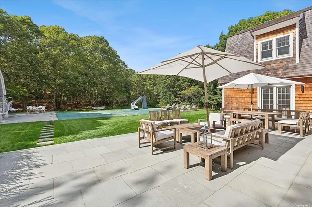 a view of a patio with a table and chairs under an umbrella