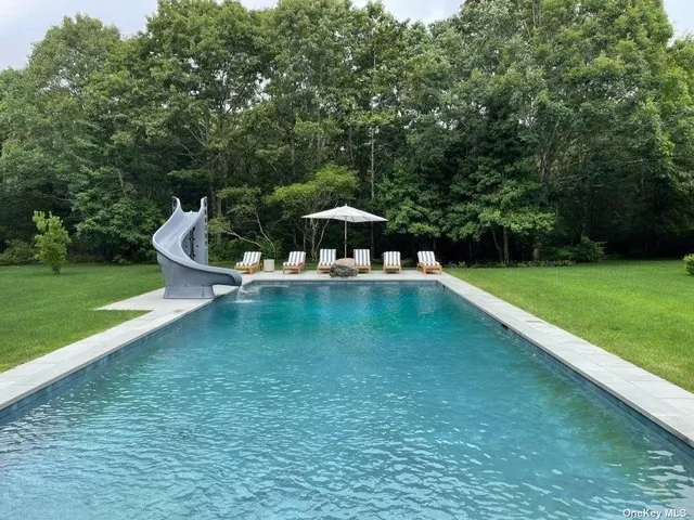 a swimming pool with outdoor seating and yard