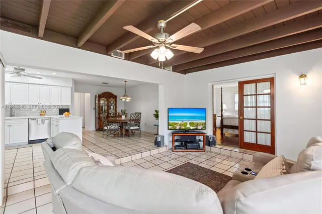 a living room with furniture a flat screen tv and a floor to ceiling window