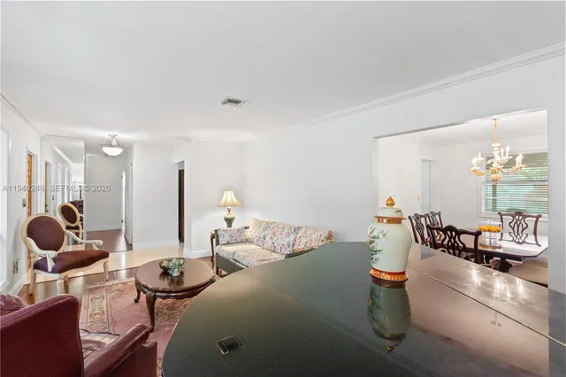 a view of a dining room with furniture a chandelier and wooden floor