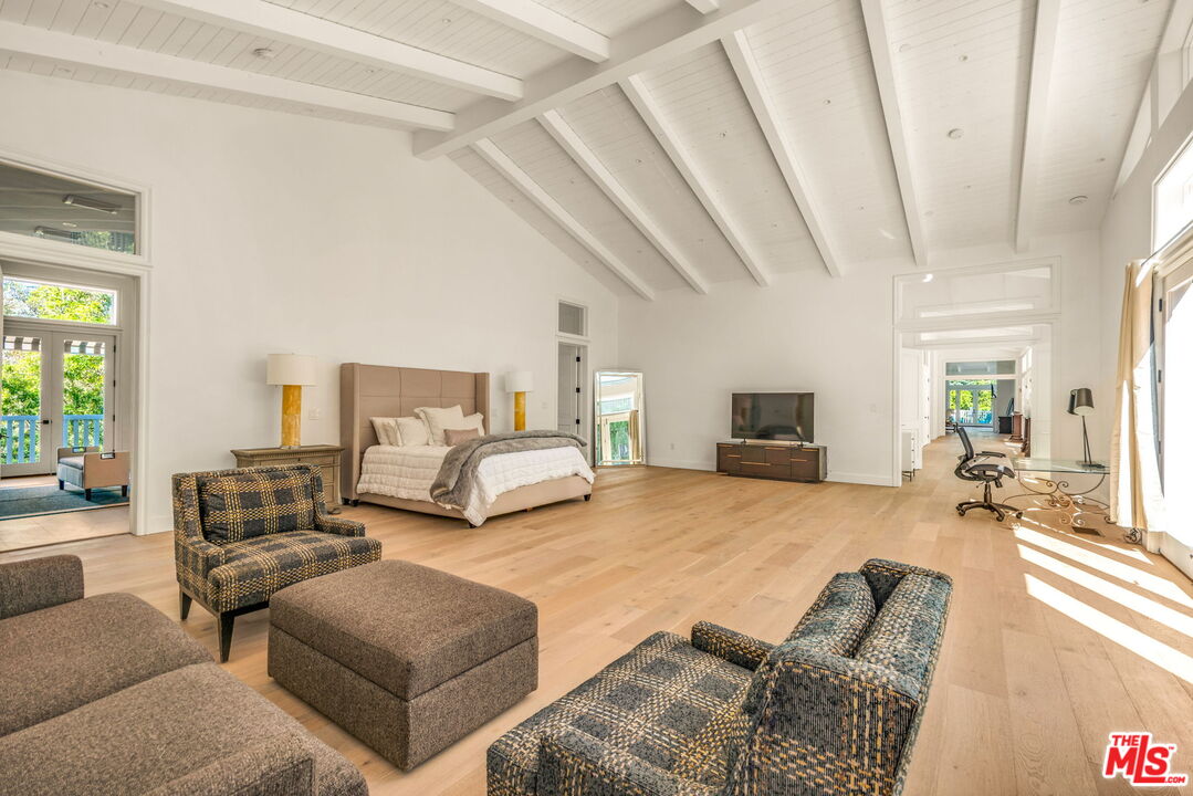 9669 Oak Pass Road Beverly Hills, CA 90210 - Photo 21 of 37 a bedroom with furniture and a flat screen tv