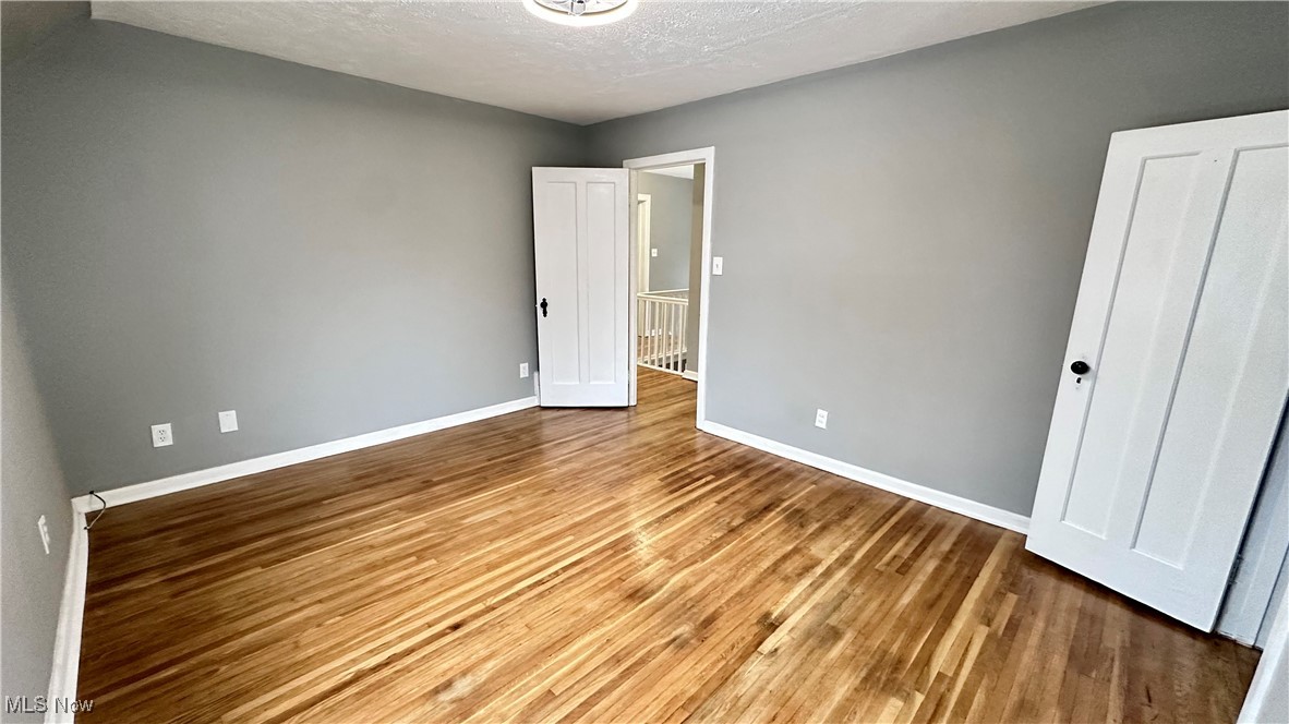 1914 Seneca Road Euclid, OH 44117 - Photo 18 of 30 Unfurnished bedroom featuring baseboards, a textured ceiling, and wood finished floors