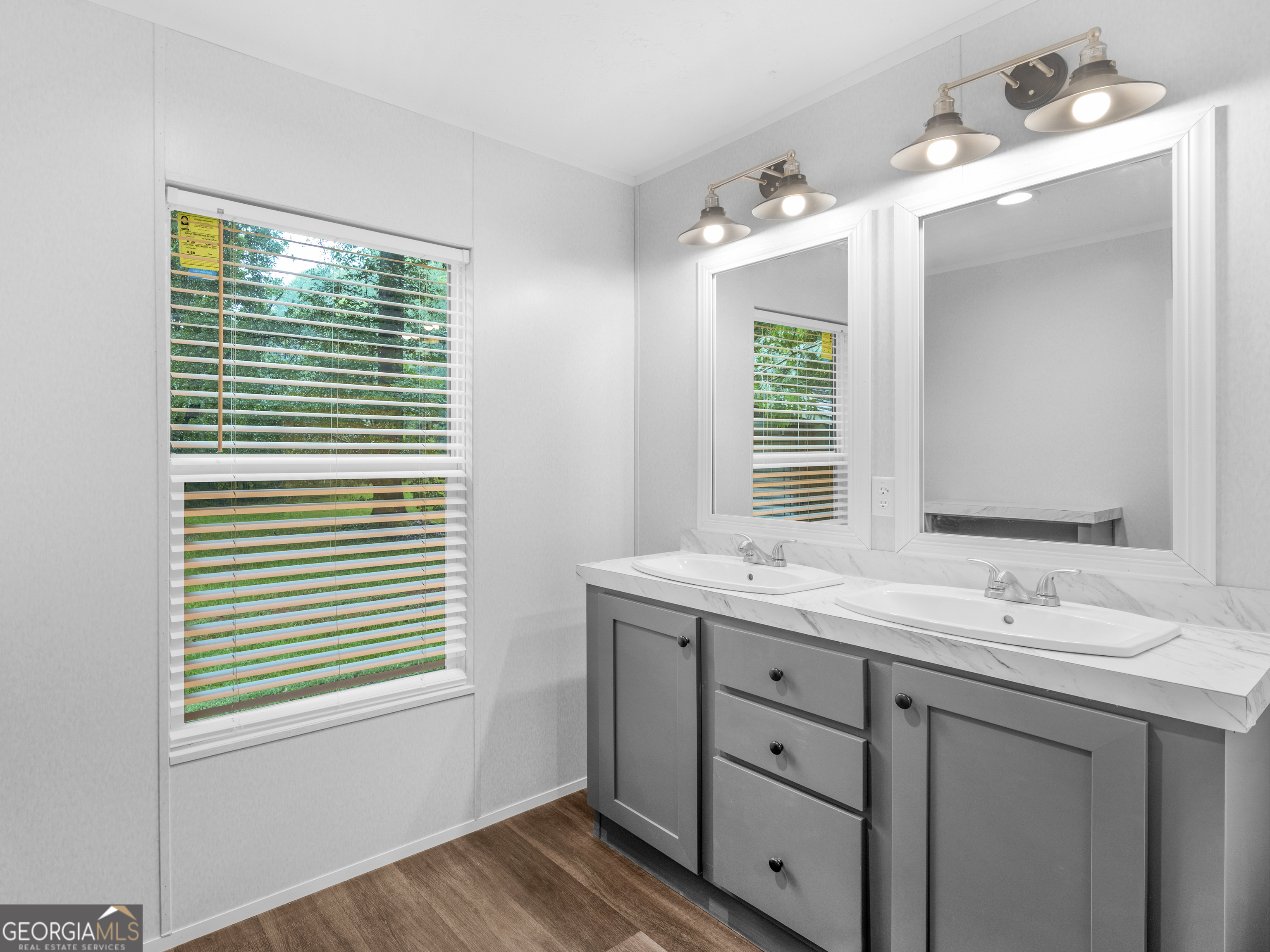 115 Gregory Lane Eatonton, GA 31024 - Photo 48 of 62 a bathroom with a double vanity sink and mirror with window