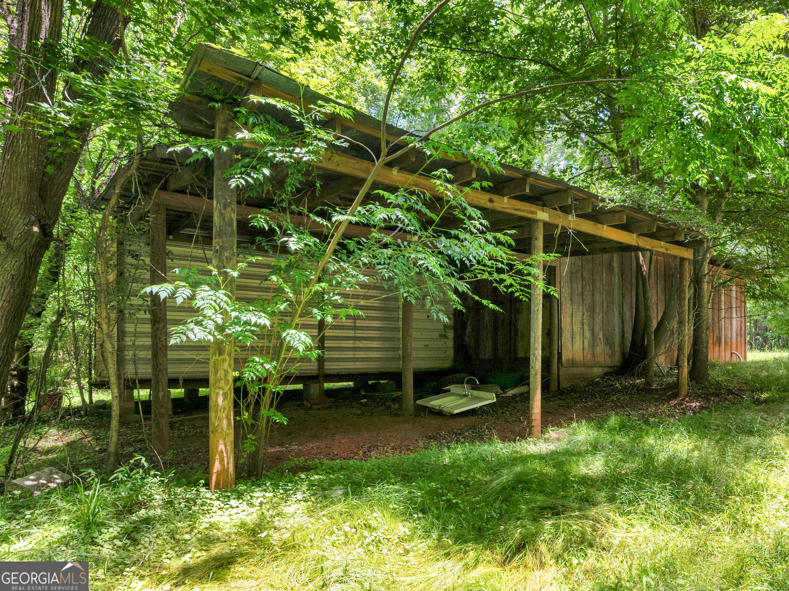 115 Gregory Lane Eatonton, GA 31024 - Photo 59 of 62 a backyard of a house with plants and tree
