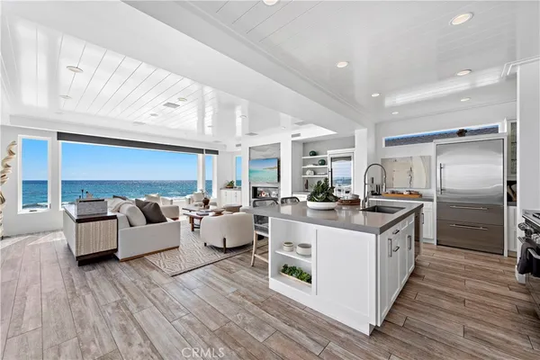 a kitchen with stainless steel appliances kitchen island granite countertop a dining table chairs and sink