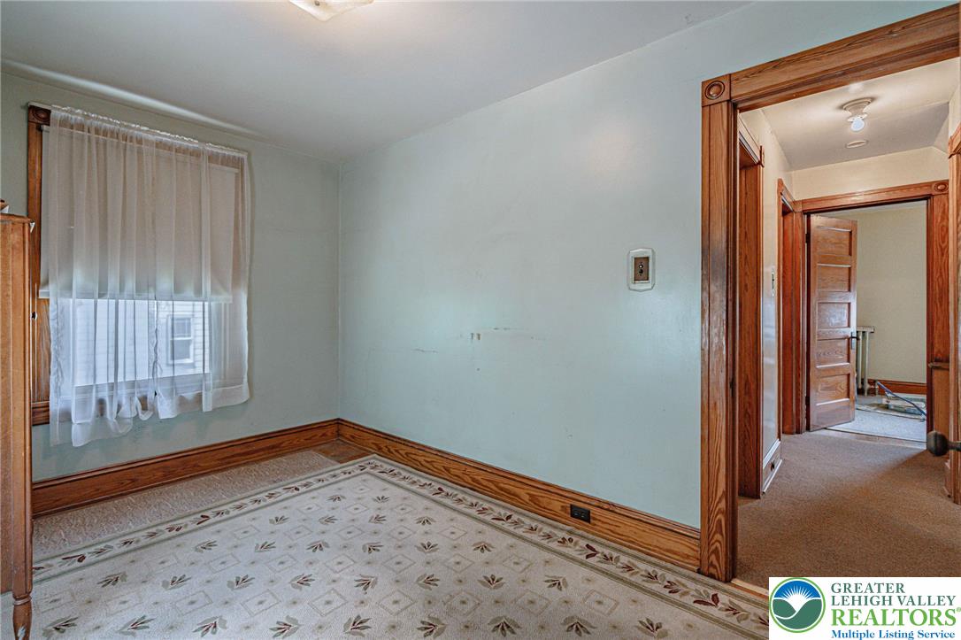 159 West Ridge Street Nesquehoning, PA 18240 - Photo 23 of 55 A well-lit room with decorative carpet and classic wood trim, ready for personalization.