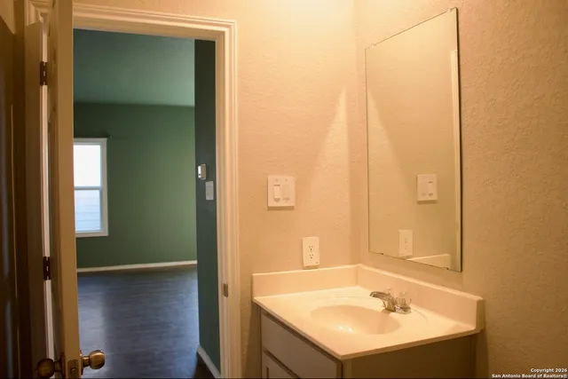 a bathroom with a granite countertop toilet a sink and a mirror