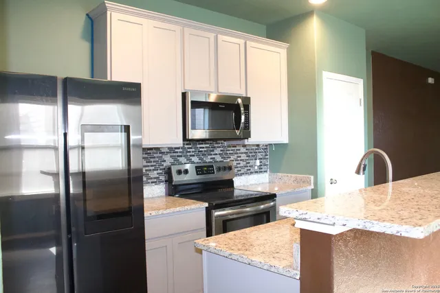 a kitchen with refrigerator and microwave