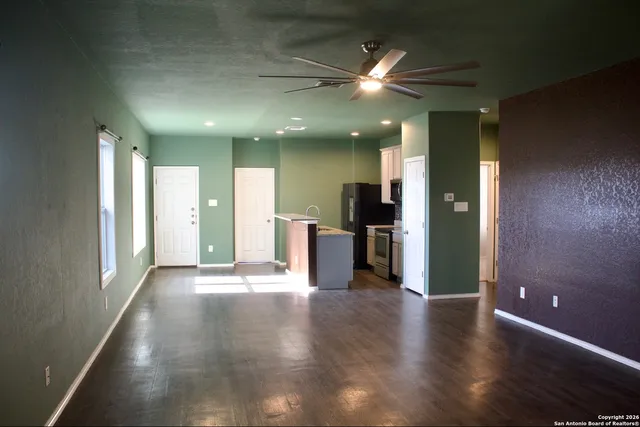 a view of a hallway with wooden floor and a large window