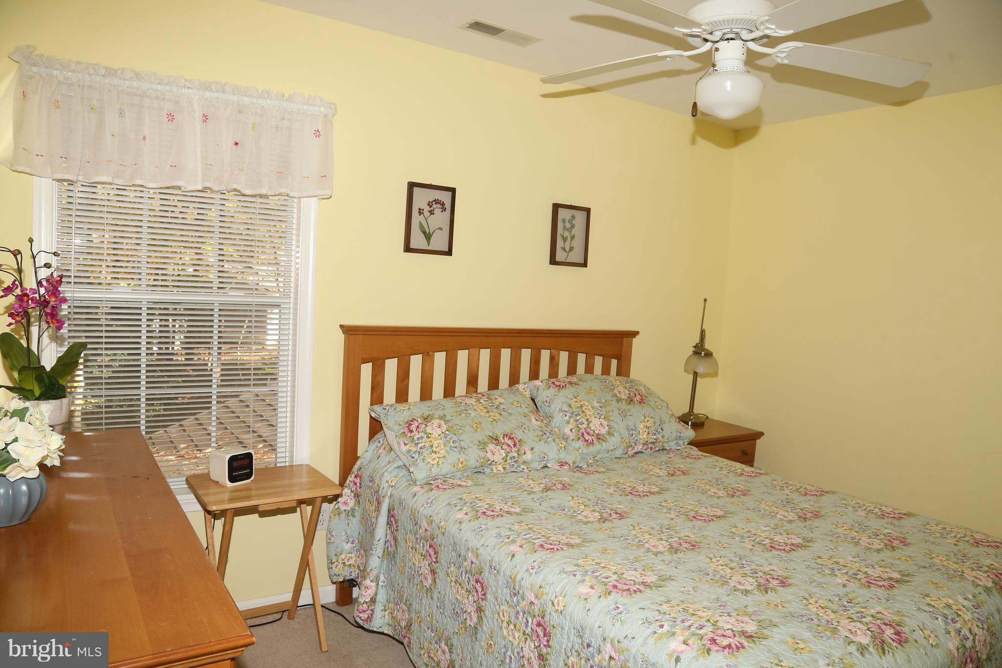 43 Falcon Bridge Road Ocean Pines, MD 21811 - Photo 16 of 30 a bed sitting in a bedroom next to a window and a chandelier