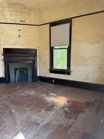a view of an empty room with a fireplace and a window