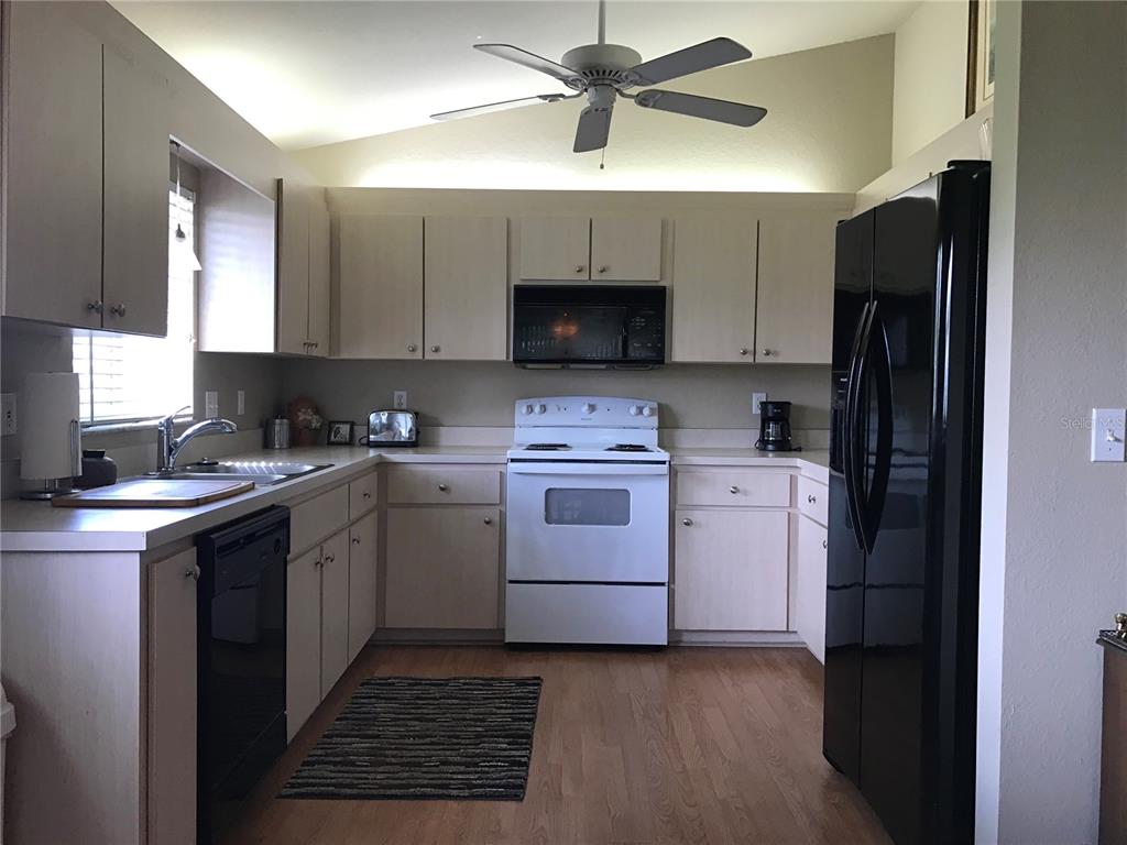 11879 Southwest 137th Loop Dunnellon, FL 34432 - Photo 23 of 37 a kitchen with a sink stove and refrigerator