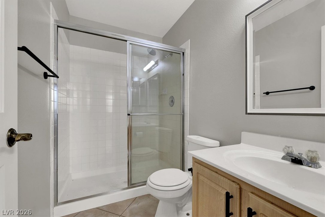 10148 Tree Bark Street Las Vegas, NV 89183 - Photo 28 of 37 A streamlined walk-in shower offers refreshing simplicity in this bright bathroom.