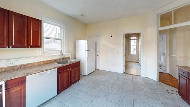 a large kitchen with granite countertop a refrigerator and a sink