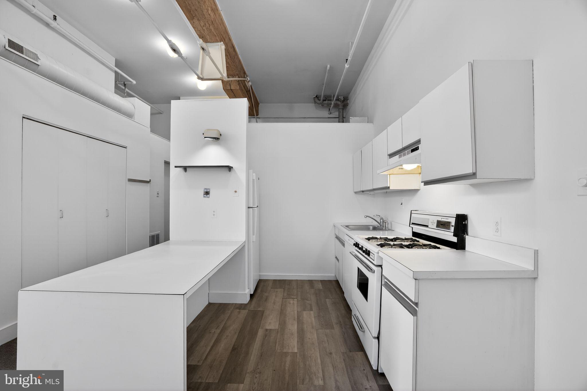 408 Vine Street, Unit 2A Philadelphia, PA 19106 - Photo 11 of 19 a kitchen with stainless steel appliances a white stove top oven and a sink