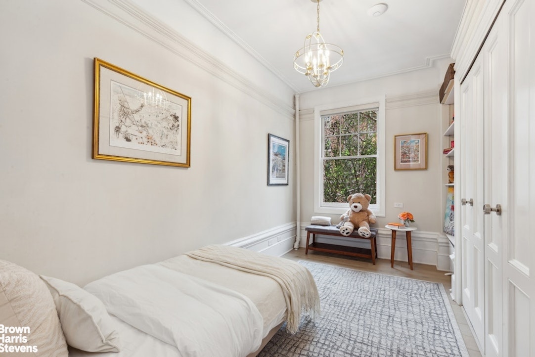 37 West 93rd Street, Unit 17/13 Manhattan, NY 10025 - Photo 9 of 11 a bedroom with a bed and a chandelier