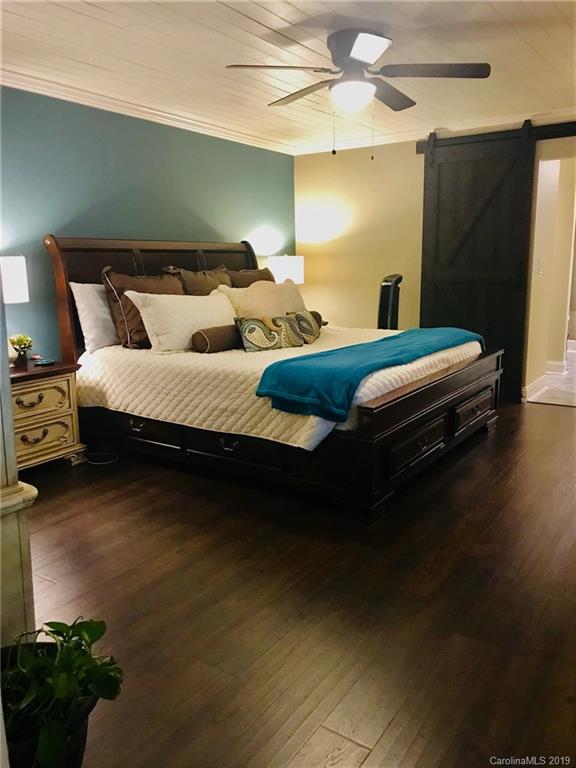 114 Riverview Road Tryon, NC 28782 - Photo 11 of 32 a bedroom with bed and a chandelier