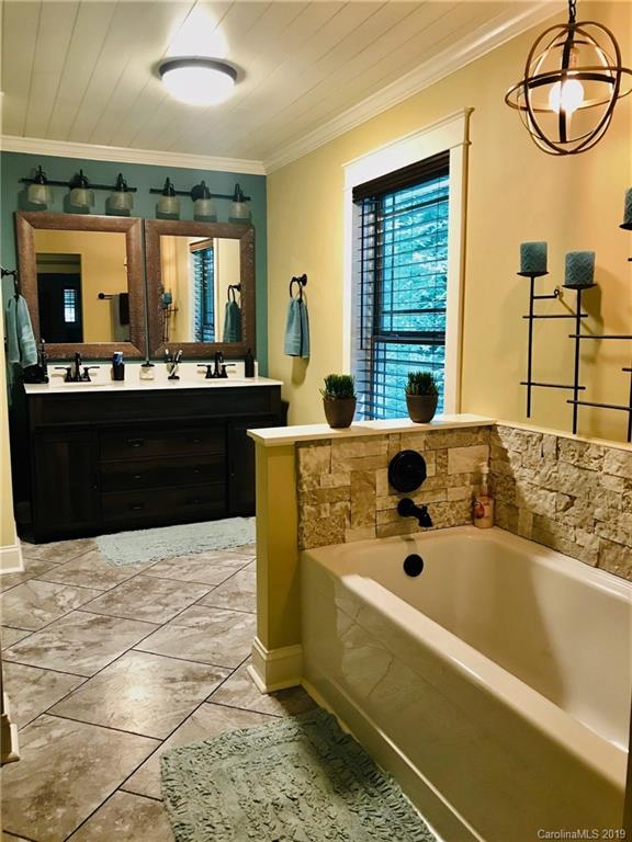 114 Riverview Road Tryon, NC 28782 - Photo 14 of 32 a spacious bathroom with a tub sink and mirror