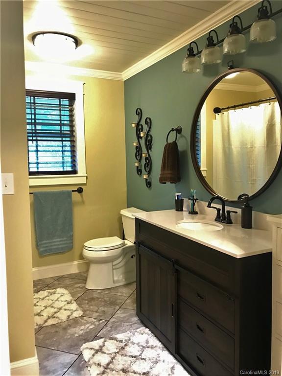 114 Riverview Road Tryon, NC 28782 - Photo 20 of 32 a bathroom with a toilet sink and mirror