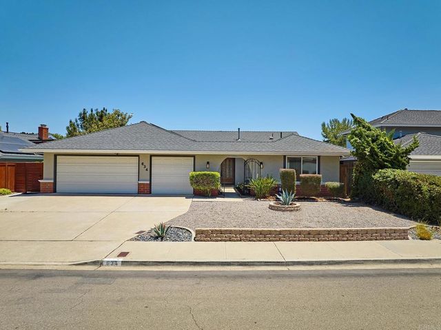 a front view of house with yard and mountain view in back