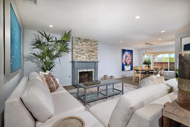 a living room with furniture fireplace and a potted plant