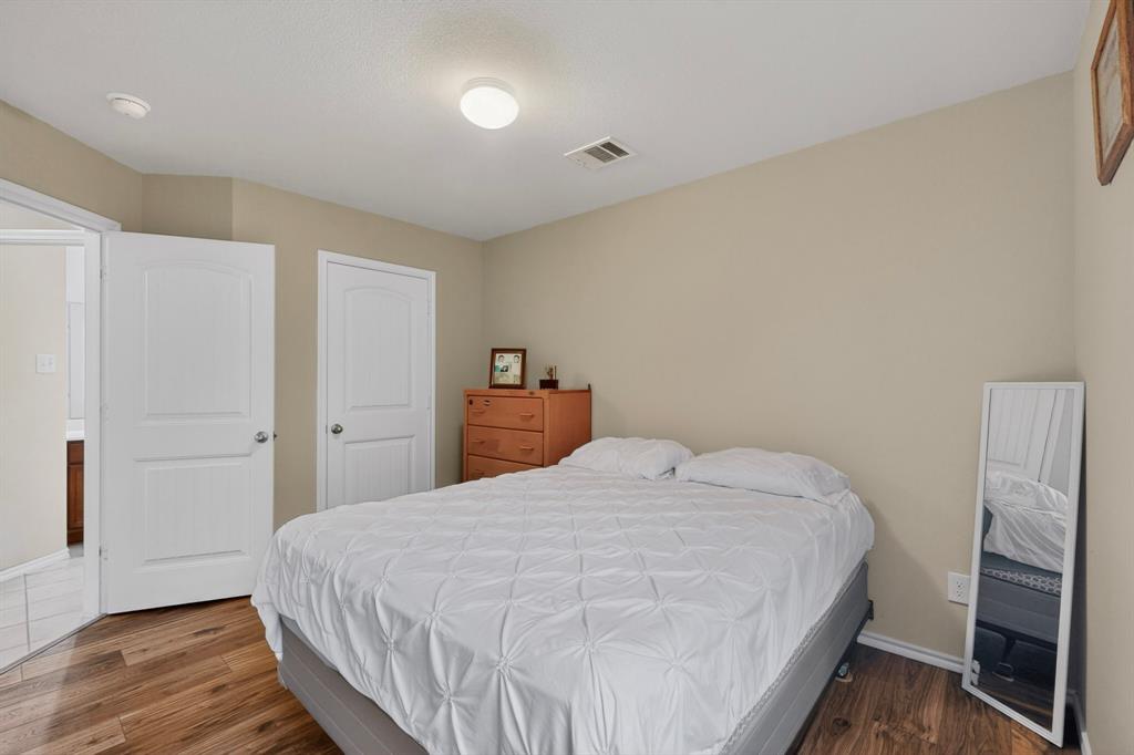 1409 Slate Street Princeton, TX 75407 - Photo 22 of 36 Bedroom featuring wood-finish flooring, neutral wall paint, white trim, and a ceiling-mounted light fixture