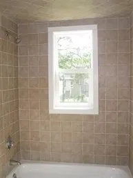a bathroom with a window a bathtub and shower