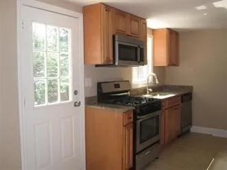 a kitchen with stainless steel appliances granite countertop a stove a microwave and a sink
