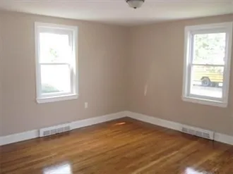 a view of a room with wooden floor and windows