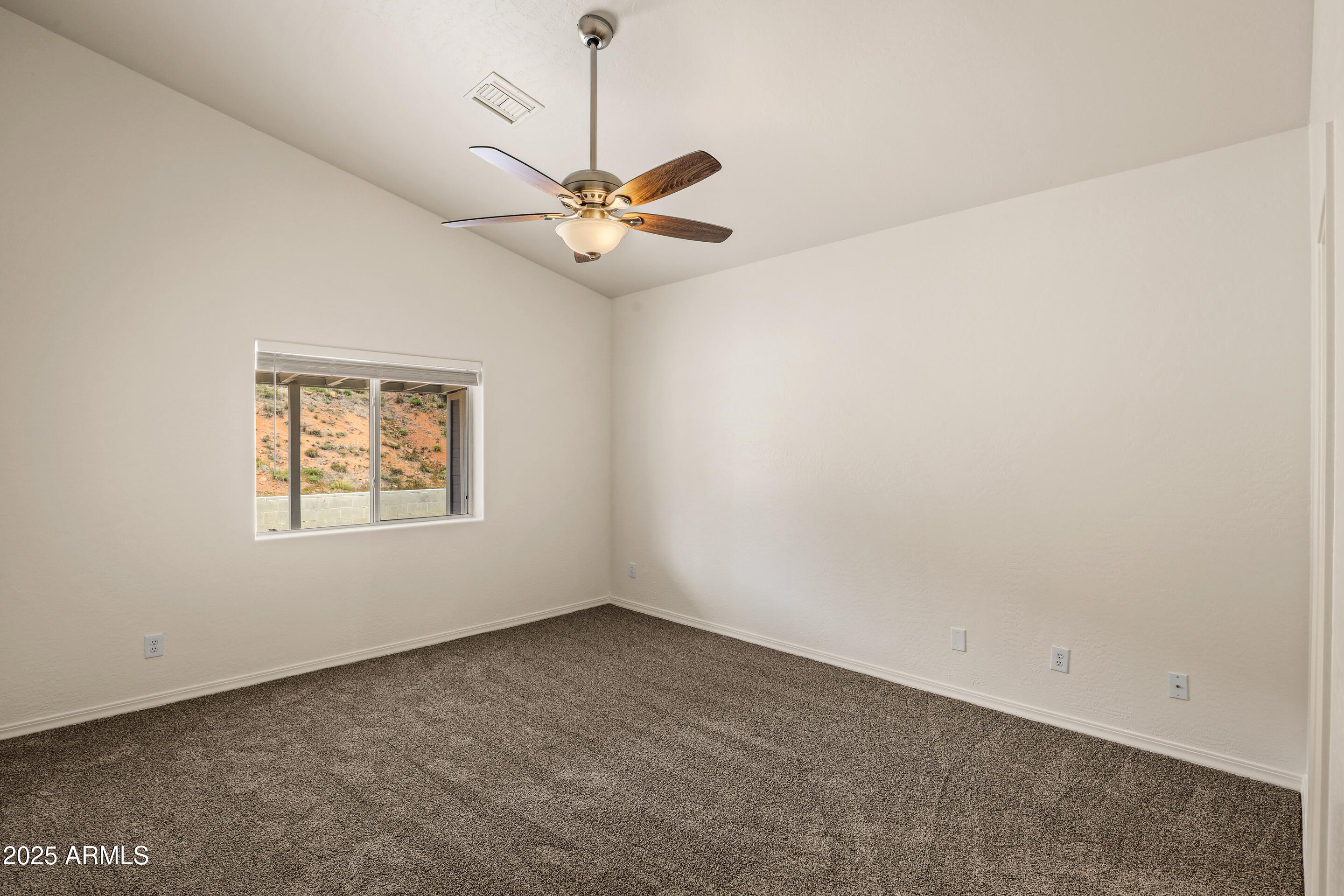 1014 West Summit Street Payson, AZ 85541 - Photo 7 of 21 an empty room with a window and a fan