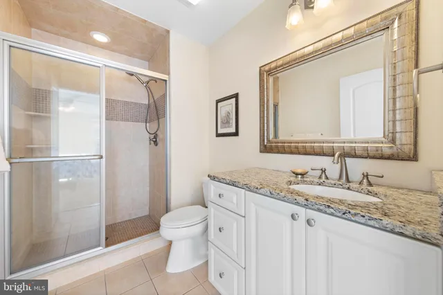 a bathroom with a granite countertop sink toilet and shower