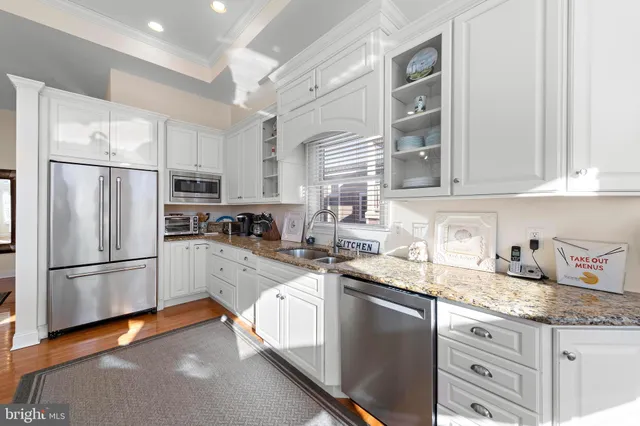 a kitchen with kitchen island a counter space a sink appliances and cabinets