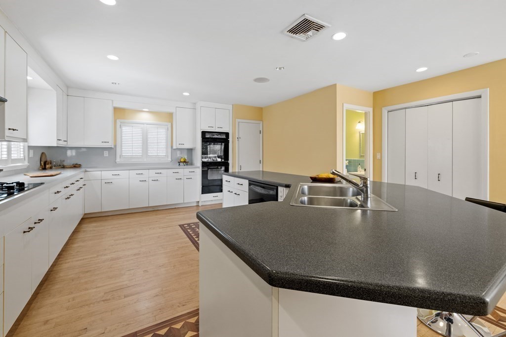77 Hallwood Road Brookline, MA 02467 - Photo 14 of 42 a large kitchen with kitchen island a large counter top space a sink stainless steel appliances and cabinets