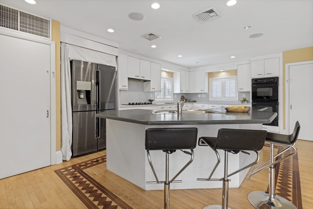 77 Hallwood Road Brookline, MA 02467 - Photo 16 of 42 a kitchen with stainless steel appliances a refrigerator stove microwave and cabinets