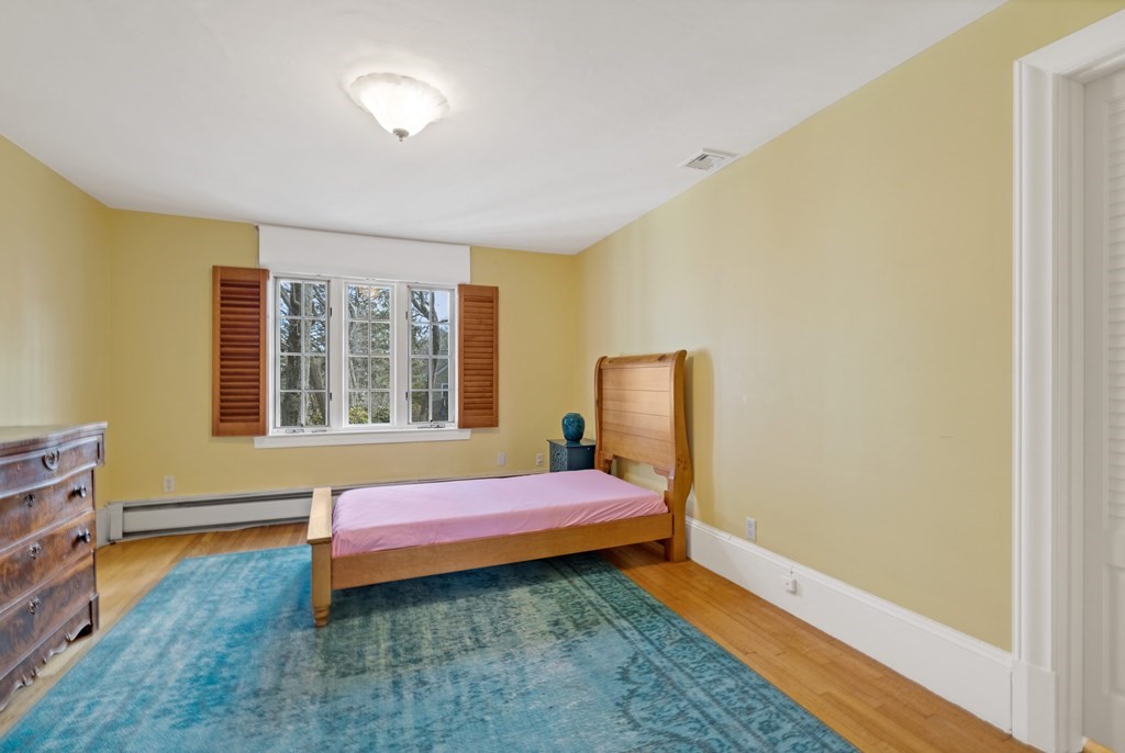 77 Hallwood Road Brookline, MA 02467 - Photo 30 of 42 a bedroom with a bed and wooden floor
