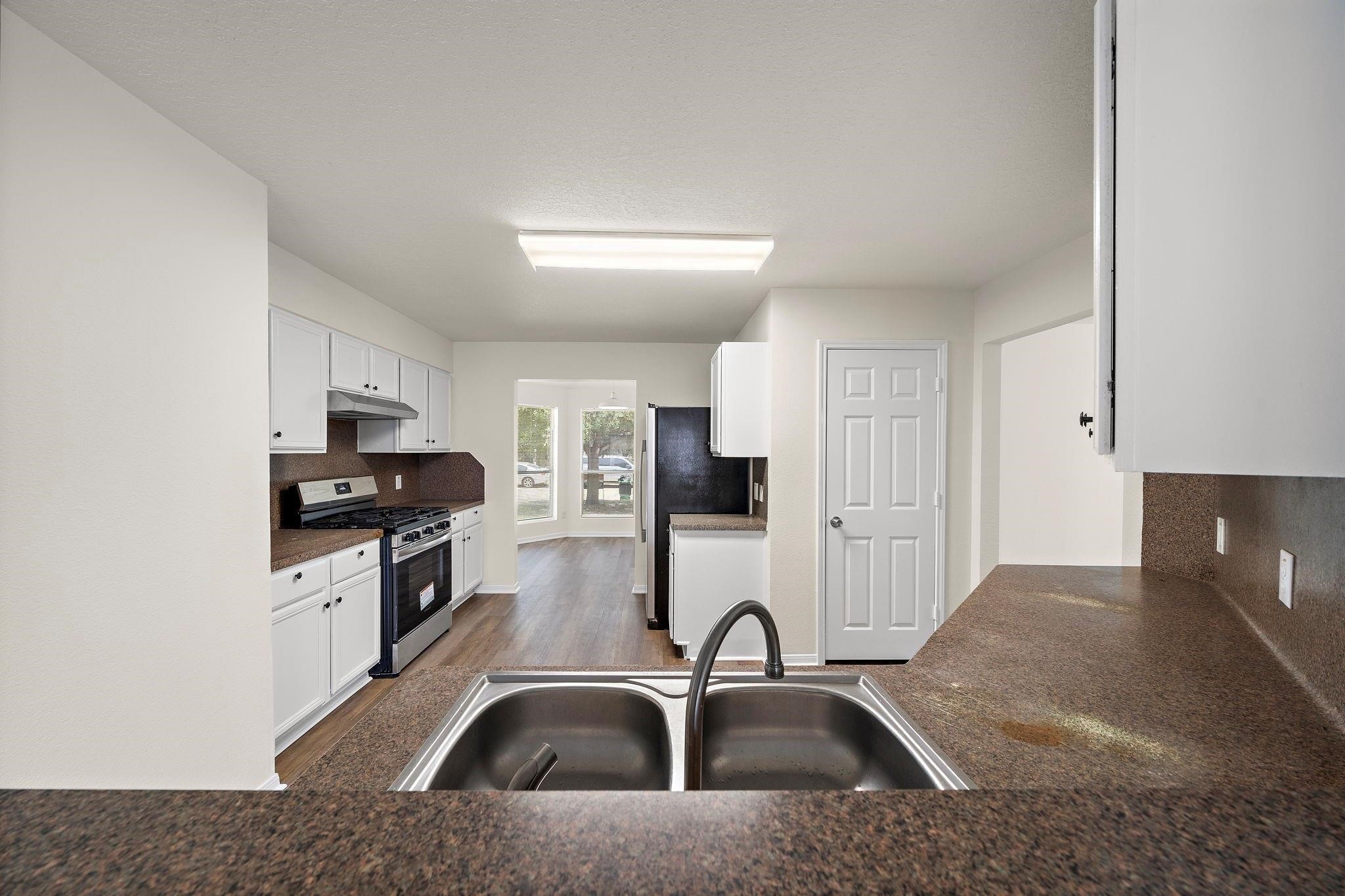 3235 Clipper Winds Way Houston, TX 77084 - Photo 12 of 26 a kitchen with a sink a stove and cabinets