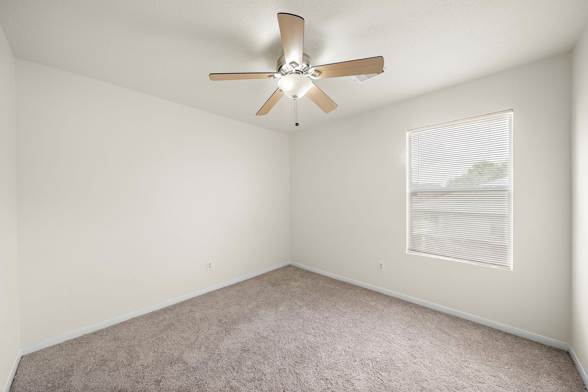 3235 Clipper Winds Way Houston, TX 77084 - Photo 6 of 26 an empty room with a window and a fan